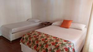 a room with two beds and a night stand at Meson Hondano in Honda