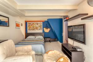 a bedroom with a bed and a couch and a tv at B&B 1971 Hazenstraat - Shared Bathroom in Amsterdam