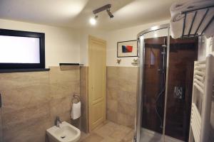ein Bad mit einer Dusche und einem WC sowie ein TV in der Unterkunft Le Giare in Trecastagni