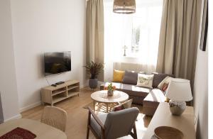a living room with a couch and a table at Apartament na Jeziornej in Kartuzy