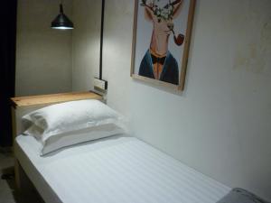 a bedroom with a bed with a picture of a deer on the wall at Ola Hostel in Melaka