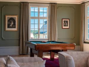 a billiard room with a pool table and a window at Johannesbergs Slott in Rimbo