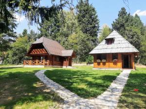 uma cabana de madeira num parque com um caminho que o conduz em Zlatiborske brvnare em Zlatibor
