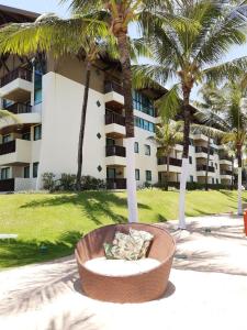 嘎林海斯港的住宿－Marulhos Suites Resort StudioTerreo，棕榈树建筑前的沙发