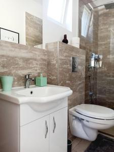 bagno con lavandino bianco e servizi igienici di Almond Apartments a Sveti Stefan