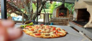 a pizza sitting on top of a table next to an oven at Maison avec piscine chauffée et pool house in Saint-Mont