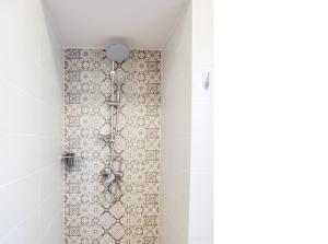 łazienka z prysznicem i ścianą wyłożoną kafelkami. w obiekcie Apartament na Jeziornej w Kartuzach