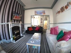 sala de estar con sofá y chimenea en Blackpool Abode - Seaside Cove, en Blackpool