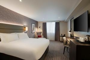um quarto de hotel com uma cama grande e uma televisão em Leonardo Hotel Chester em Chester