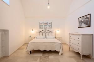una camera bianca con letto e cassettiera di Quercus ad Alberobello