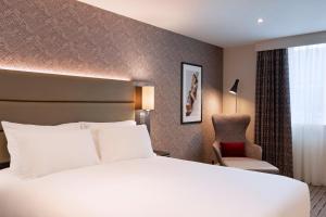 a hotel room with a white bed and white walls at Leonardo Hotel Chester in Chester