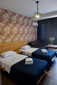 een hotelkamer met 2 bedden en een bank bij Tskaltubo Epic Hotel & Spa in Tskaltubo