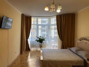 een slaapkamer met een bed en een groot raam bij VIP Апартаменти Львів Сихів центр Червоної Калини in Lviv