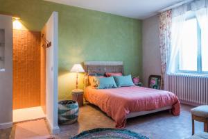 a bedroom with a bed and a green wall at Le Rucher des Arts in Alba-la-Romaine