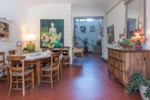 una sala da pranzo con tavolo e sedie di Le Rucher des Arts a Alba-la-Romaine