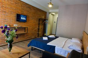 Tskaltubo Epic Hotel & Spa في تسكالتوبو: غرفة نوم بسرير وجدار من الطوب