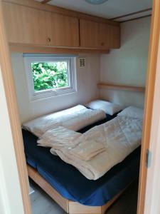 twee bedden in een kleine kamer met een raam bij Chalet 4-6 Personen Epe F15 Van alle gemakken voorzien Max aantal volwassen personen bedraagt 4 in Epe