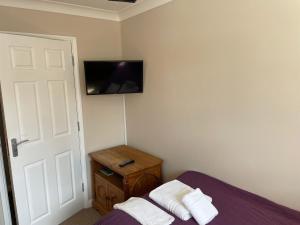a bedroom with a bed and a tv on the wall at Longs Hotel & Inn in Woburn