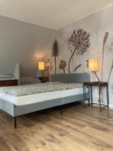 uma cama num quarto com uma parede com flores em Hotel Gästehaus Hochmann Stadecken em Stadecken-Elsheim