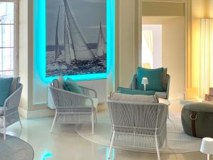 a living room with chairs and a picture of two sailboats at Hotel Miramare & Spa in Sestri Levante