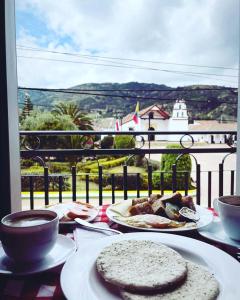 a table with plates of food and a view of a balcony at Camino A La Villa Cucaita Hotel in Cucaita