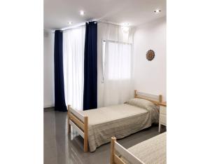 a bedroom with two beds and a window at Nonna Lucia in Molfetta