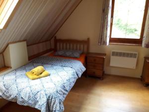 a bedroom with a bed with a yellow towel on it at Domček pod Starým mestom in Banská Štiavnica