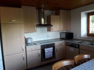 a kitchen with wooden cabinets and a stove top oven at Domček pod Starým mestom in Banská Štiavnica