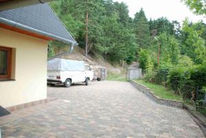 a white truck parked next to a house with a driveway at Domček pod Starým mestom in Banská Štiavnica