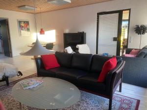 a living room with a couch and a table at Hyggeligt byhus ved glasværkstedet på Nordmors in Sejerslev