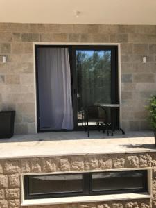 a patio with a large window and a table at REZEVICI BOUTIQUE VILLA in Petrovac na Moru