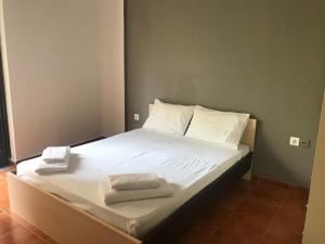 a bed with white sheets and towels on it at Amalthia Hotel Apartments in Rethymno