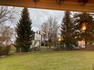 a view of a yard with trees and a house at Private Wohnung in Fürstenfeldbruck, nahe Ammersee/München/Augsburg in Fürstenfeldbruck