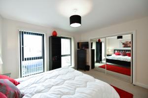 a bedroom with a large white bed and a mirror at West Portland View Apartment A in Troon
