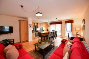 a living room with a red couch and a table at West Portland View Apartment A in Troon