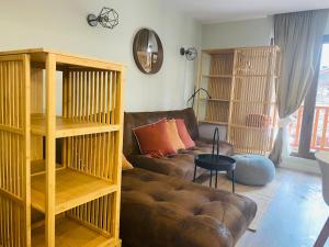 a living room with a brown leather couch and shelves at Estudio reformado Vall d'Incles Grandvalira, 4 pers, max 2 adultos y 2 niños menores 12 años in Canillo