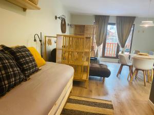 a bedroom with a bed and a living room with a table at Estudio reformado Vall d'Incles Grandvalira, 4 pers, max 2 adultos y 2 niños menores 12 años in Canillo