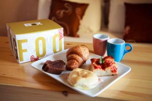 a plate of breakfast food with a box and cups at Relais Servio Tullio in Rome