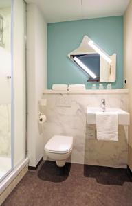 een badkamer met een toilet, een wastafel en een douche bij ibis budget Amsterdam City South in Amstelveen