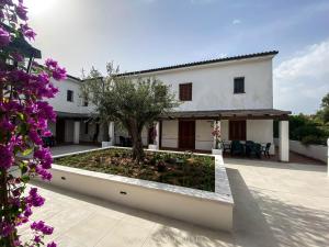 a house with a garden in front of it at White Sand Residence in Murta Maria