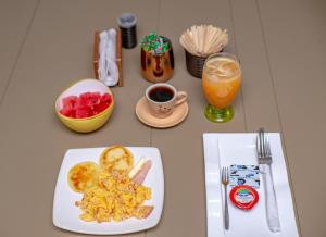 a table with a plate of breakfast food and a drink at HOTEL LA VIEJA SARA RIOHACHA in Ríohacha