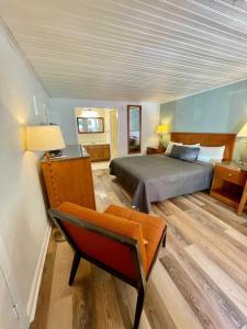 1 dormitorio con 1 cama y 1 silla en Geneva Hotel & Tiki Bar, en Lake Lure