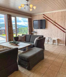 トリシルにあるIn the middle of Trysil fjellet - Welcome Center - Apartment with 4 bedrooms and sauna - By bike arena and ski liftのリビングルーム(ソファ、テーブル付)