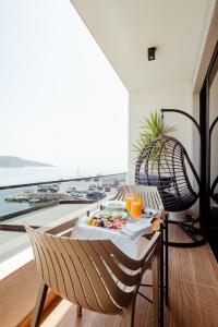 Zimmer mit einem Tisch und Stühlen sowie einem großen Fenster in der Unterkunft Rea Boutique Hotel in Himarë