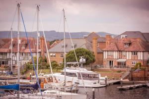 a group of boats docked in a marina with houses at Marina Dreams - couples bolthole with water views in Pevensey