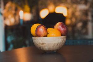 a wooden bowl of fruit on a table at City Home Ku'damm in Berlin