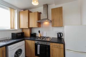 a kitchen with a stove top oven next to a refrigerator at Cherry Property - Mango Suite in Blackpool