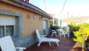 un patio avec des chaises et des tables blanches et un bâtiment dans l'établissement El Portal de la Sierra de Francia II, à San Miguel de Valero