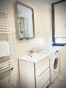 a bathroom with a washing machine and a mirror at Studio Crazy Beach Summerland in Mamaia