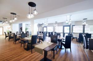 une salle à manger avec des tables, des chaises et des lumières dans l'établissement Logis Des Trois Massifs, à Claix